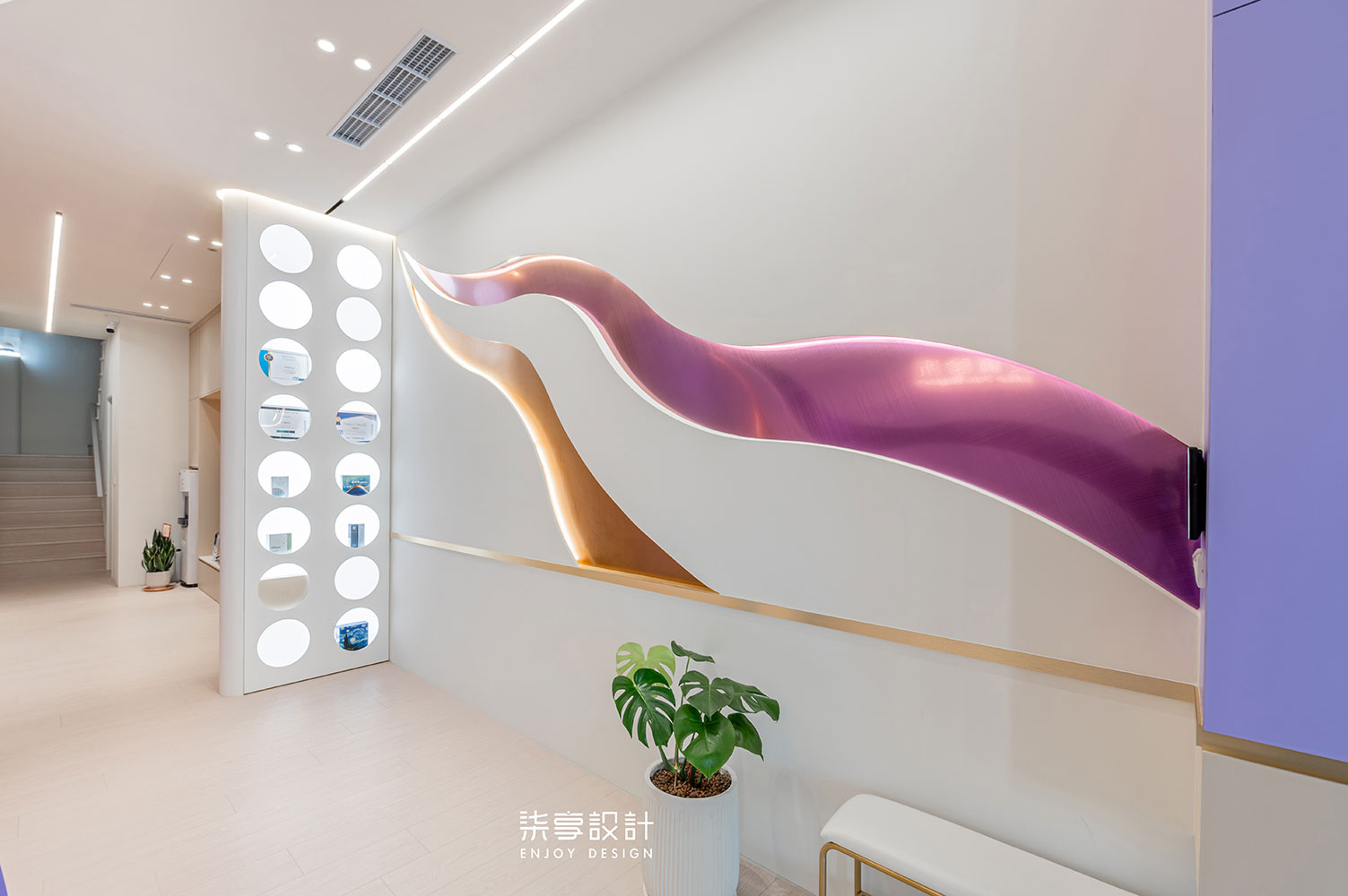 柒享設計作品高雄艾錡診所迎賓區牆面造型-從大門口一路蜿蜒至櫃內深處的流線，巧妙呼應了命理風水上的聚財格局，將無形的風水，化為有形的空間藝術。