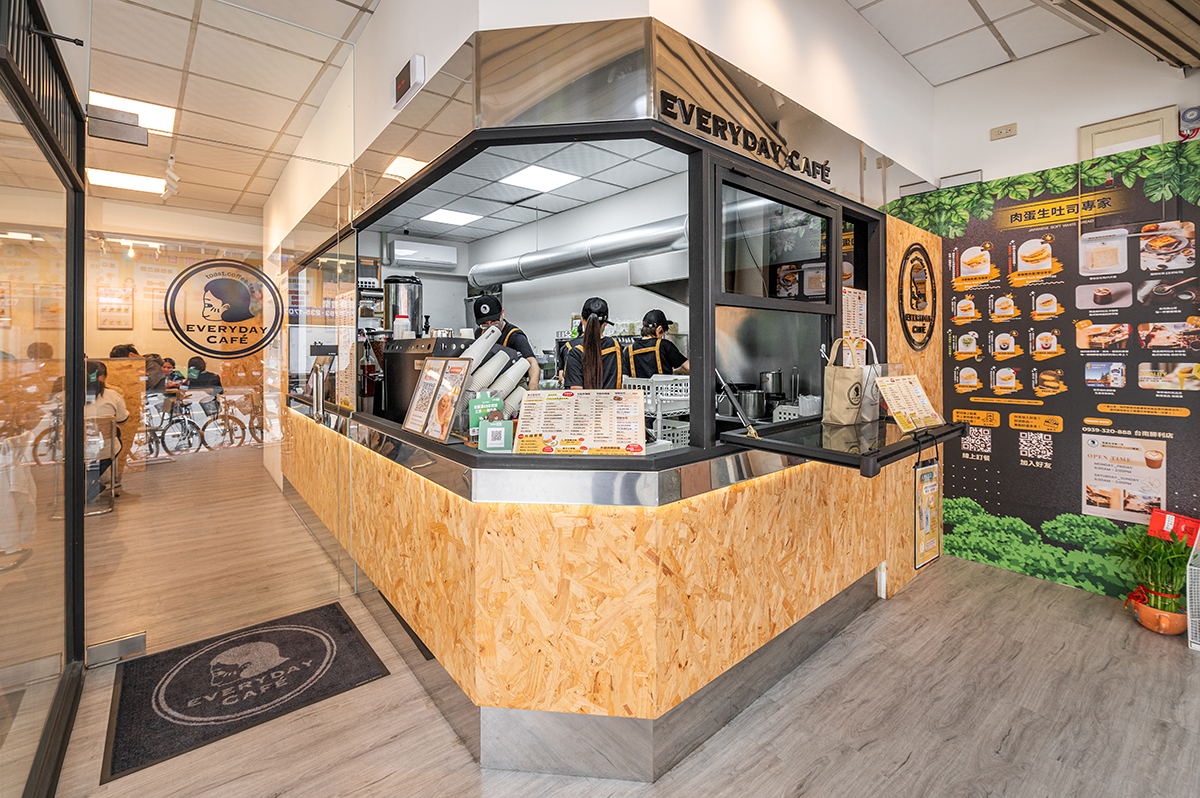 柒享設計作品台南北區EVERYDAY COFFEE早午餐商業空間設計-開放式吧台結合木質檯面與黑框設計，兼顧餐點製作效率與顧客互動，展現品牌俐落鮮明的空間特色。