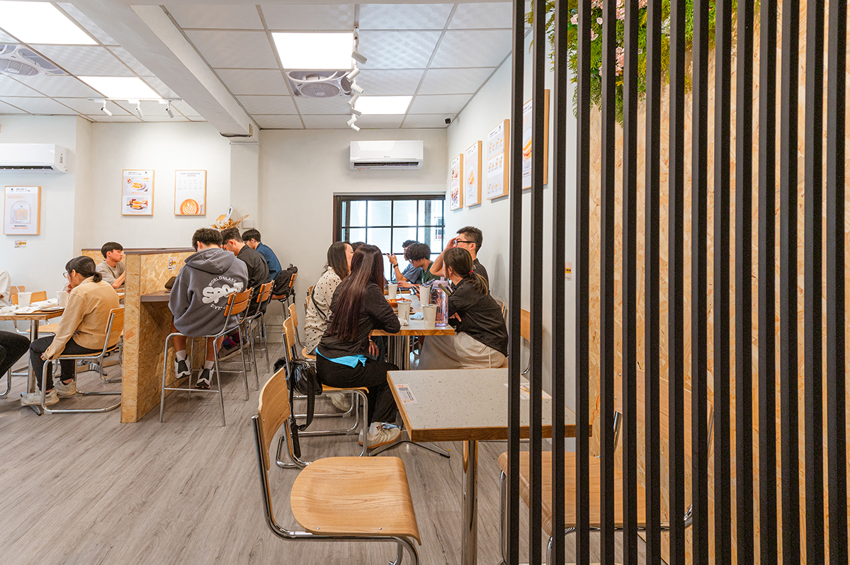 柒享設計作品台南北區EVERYDAY COFFEE早午餐商業空間設計-內用座位區以木質家具搭配簡約配色，結合格柵元素與流暢動線，打造舒適自在且富有溫度的用餐環境。